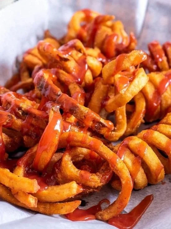 Fried French fries drizzled with ketchup.