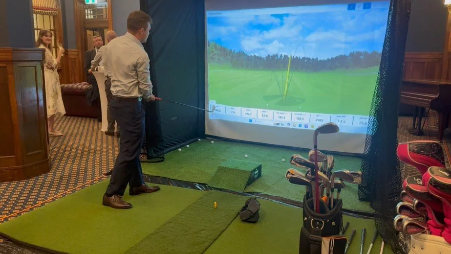 Corporate guest playing Mobile Golf simulator with a virtual golf course displayed.