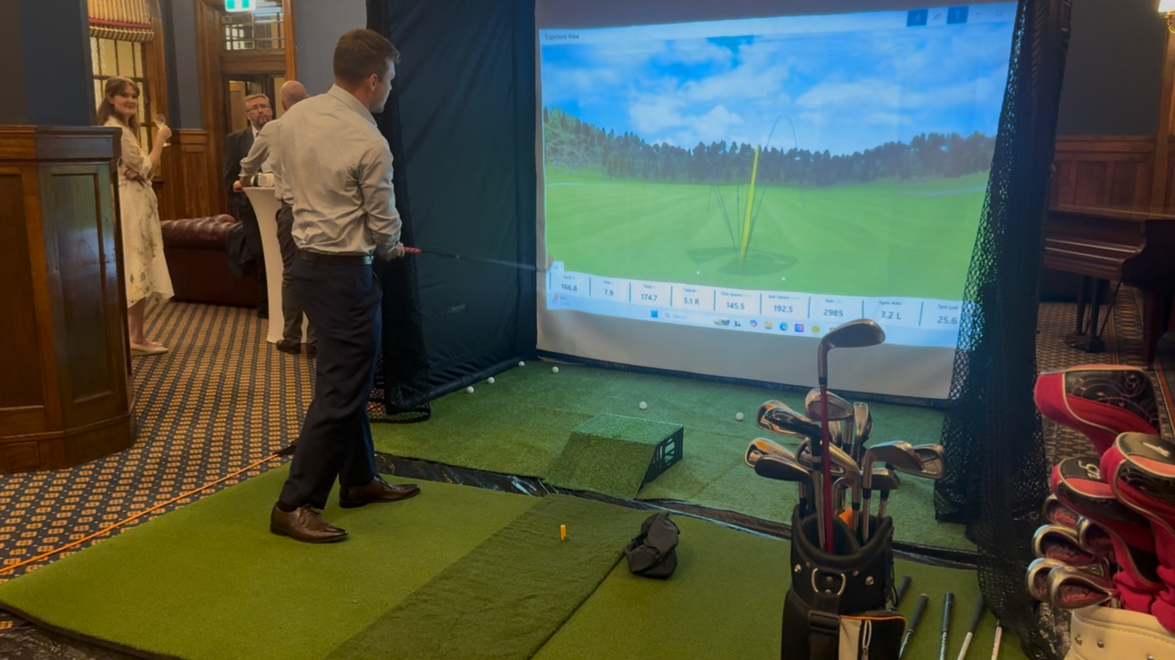Corporate guest playing Mobile Golf simulator with a virtual golf course displayed.