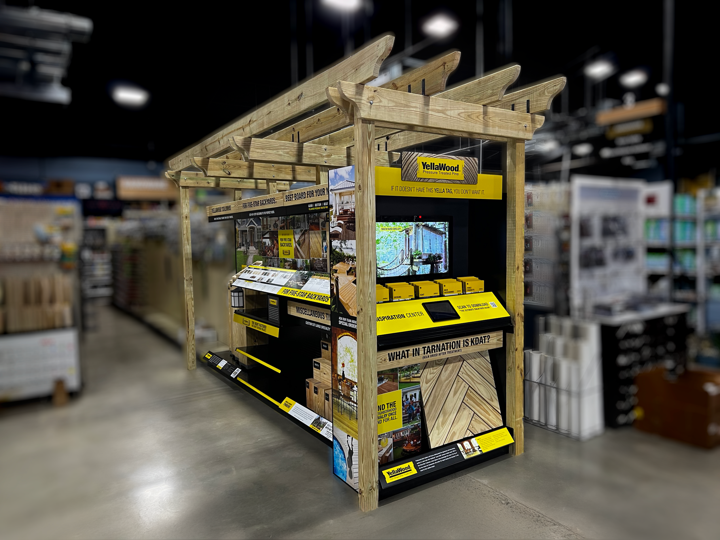 Display booth made of wooden beams and yellow signage at a hardware store, promoting backyard projects and inspiration.