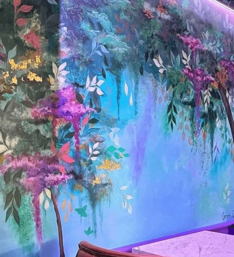 Colorful mural of a vibrant garden scene with trees, flowers, and butterflies, painted in pastel and bright colors.