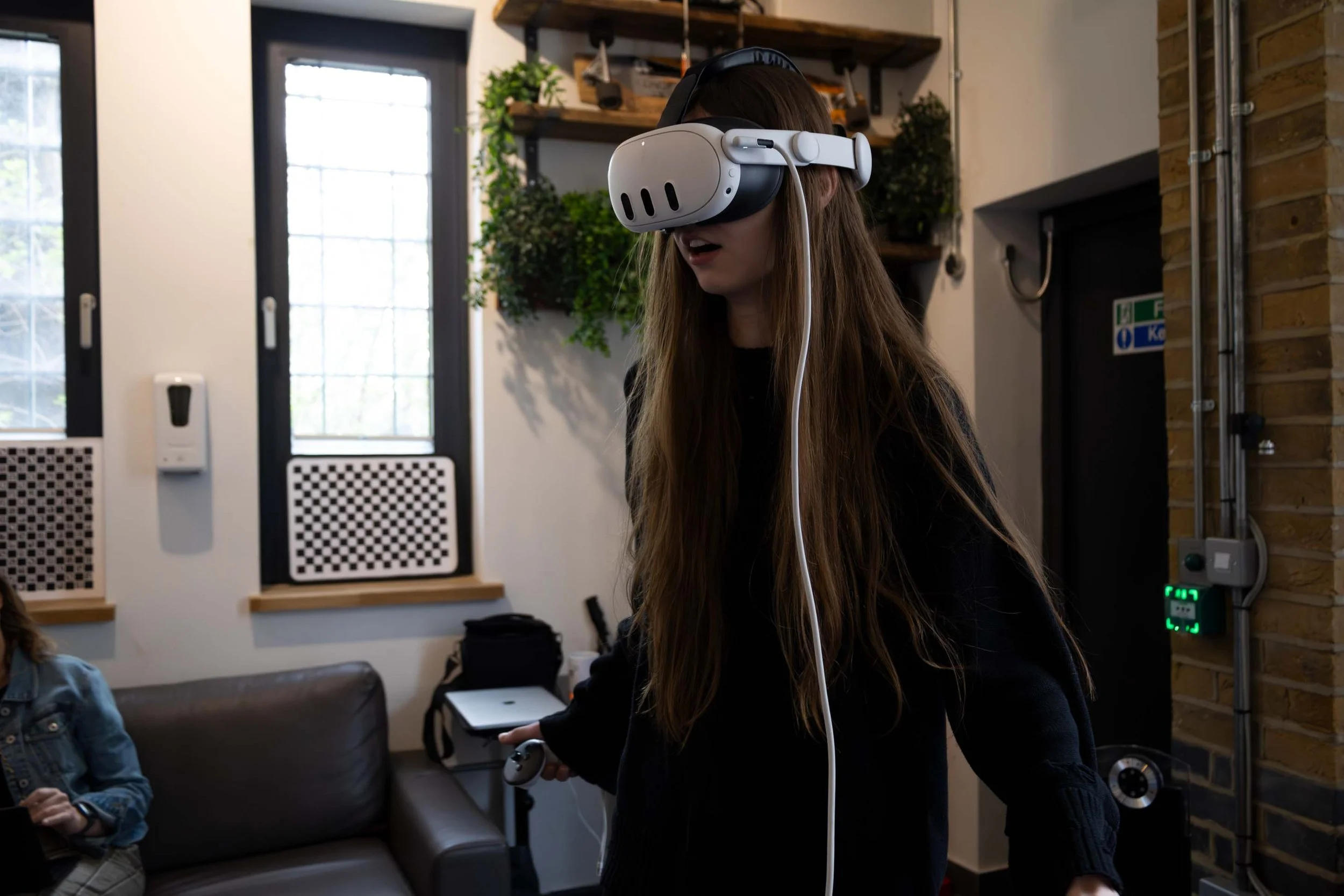 Fashion model experiencing her own volumetric runway performance through VR headset at AdventuryXR studio for immersive fashion content review