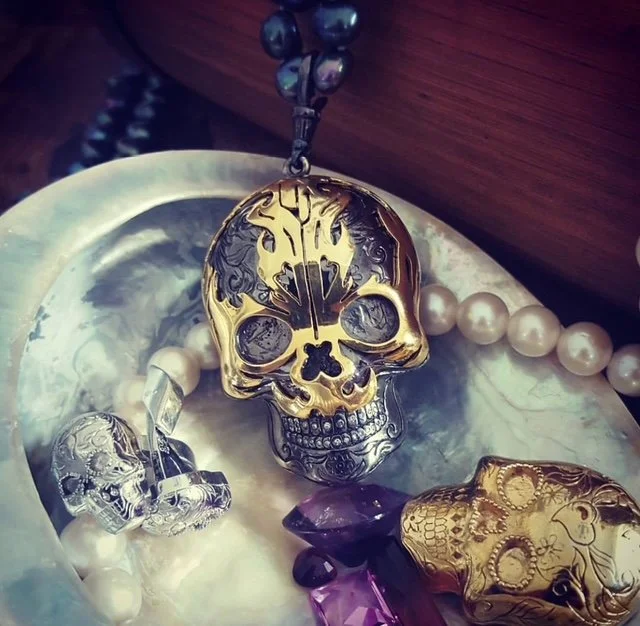 NYGP Decorative skull-shaped jewellery necklaces, pearls, and gemstones on an oyster shell plate.