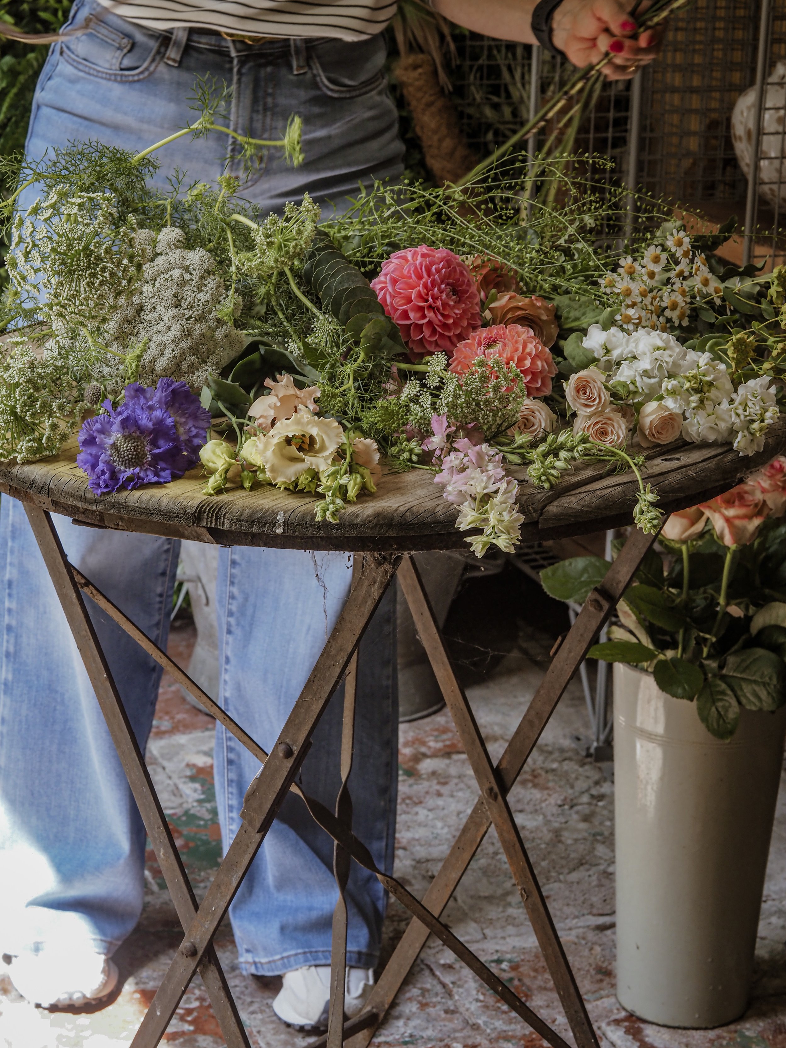 Assorted fresh flowers on a rustic wooden table in a flower shop.
