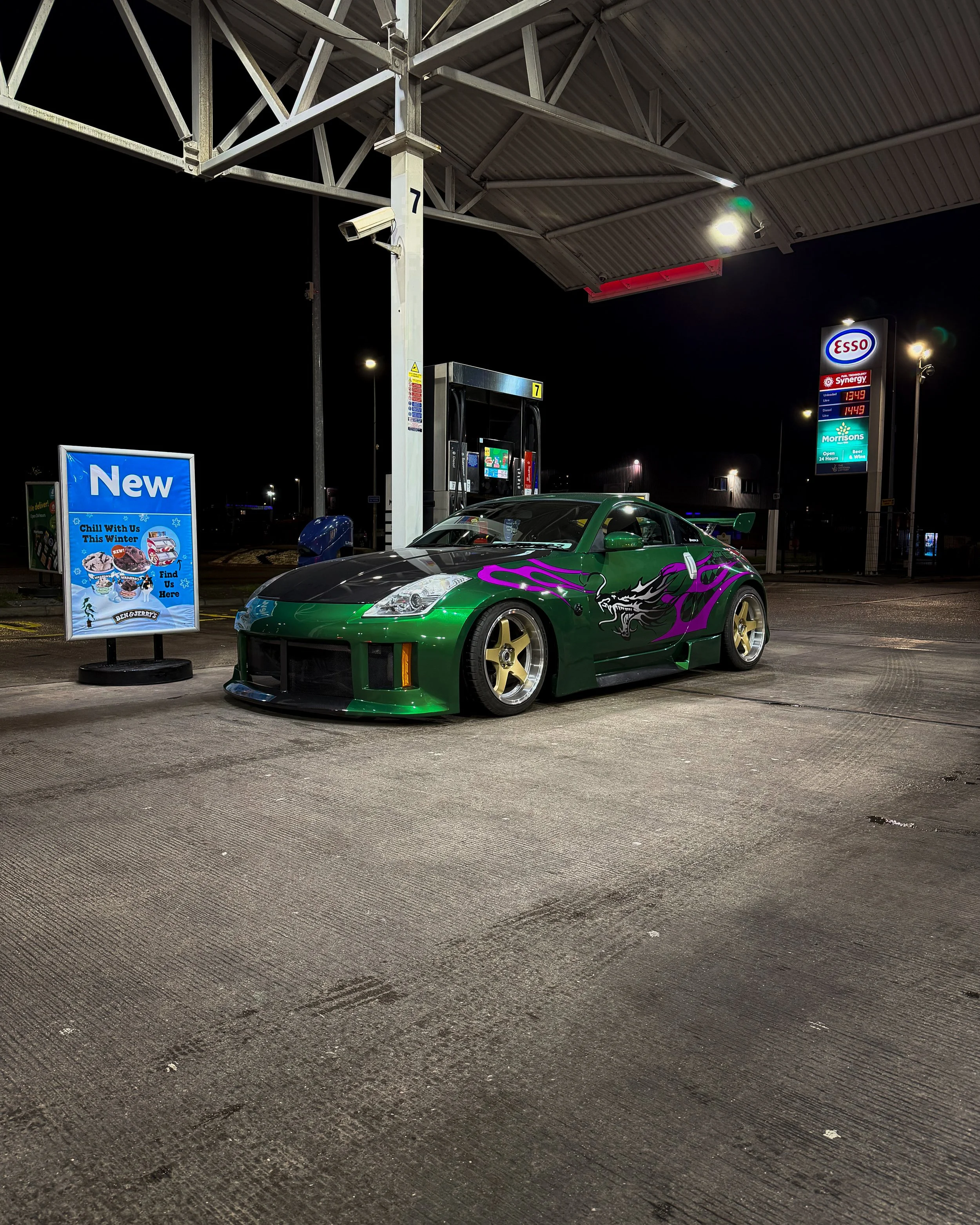 A replica of Nissan 350Z from NFS U2 parked at a gas station pump at night.