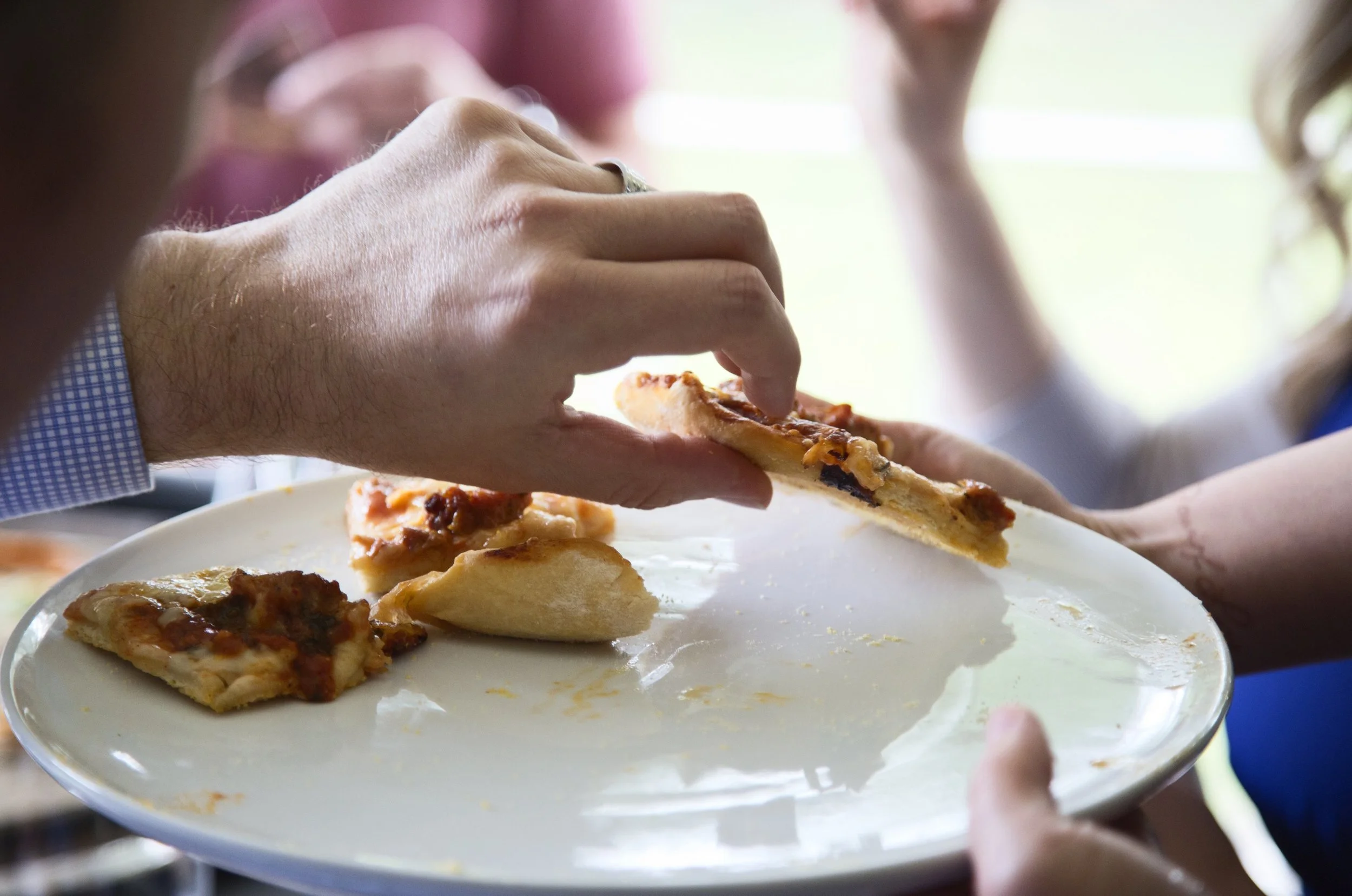People sharing slices of pizza at a gathering.
