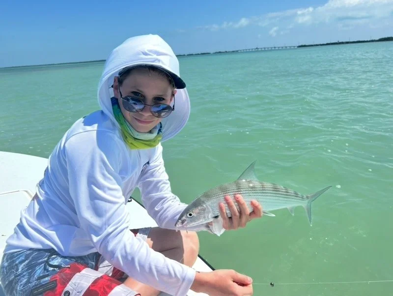 “Young angler holding a bonefish on the flats in the Florida Keys.”