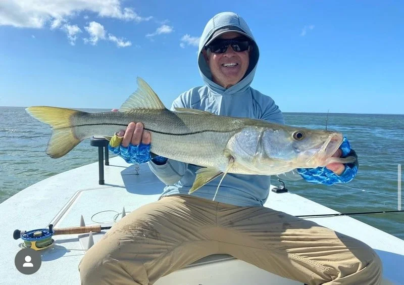 Smiling fisherman displays a snook caught on a Florida Keys fishing charter. Islamorada backcountry trips target snook, tarpon, and redfish in shallow waters.