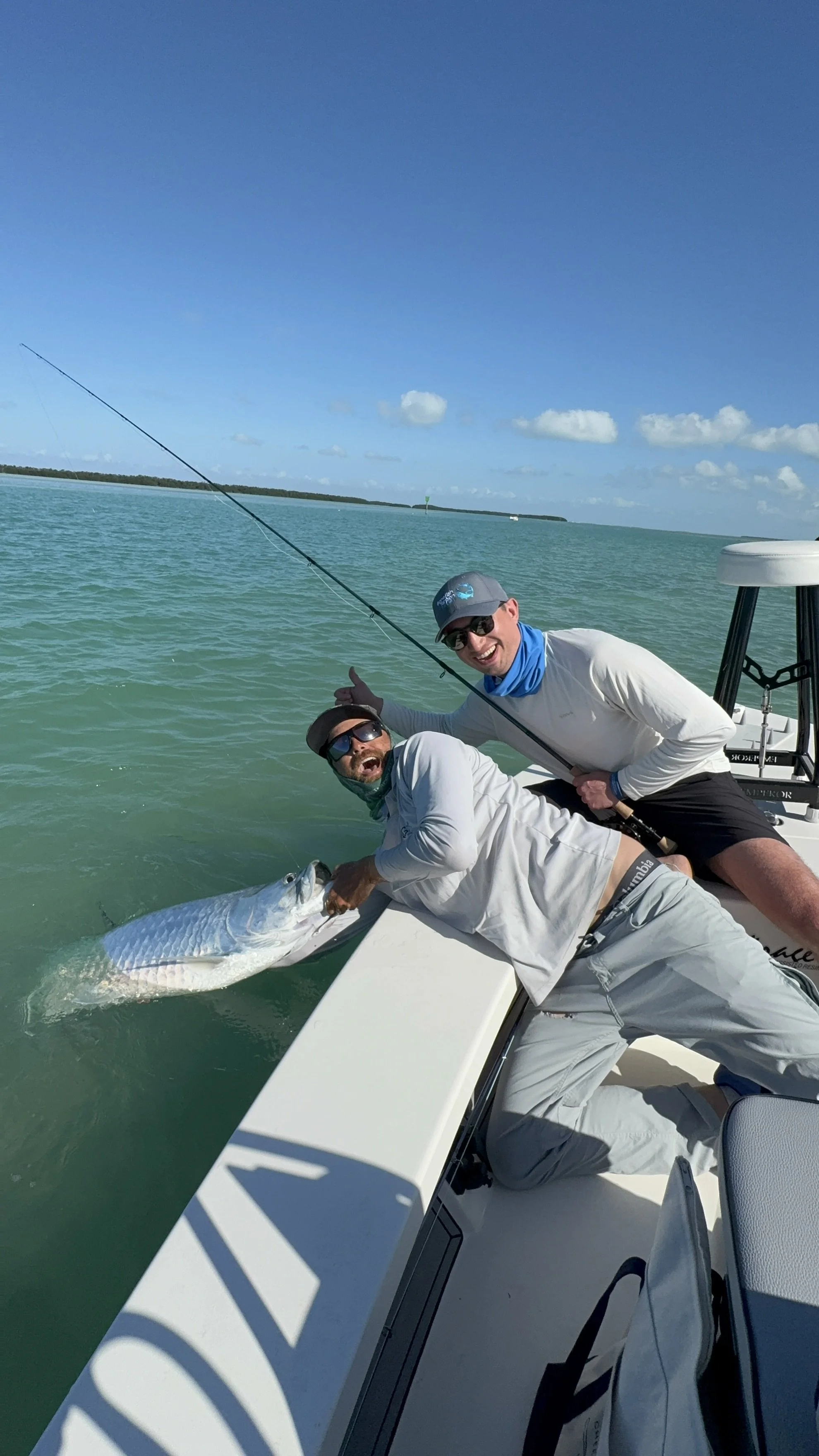 Islamorada fly fishing adventure in the Florida Keys, with a guided angler landing a powerful tarpon beside the boat—showcasing the thrill of saltwater flats fishing in the sportfishing capital of the world.