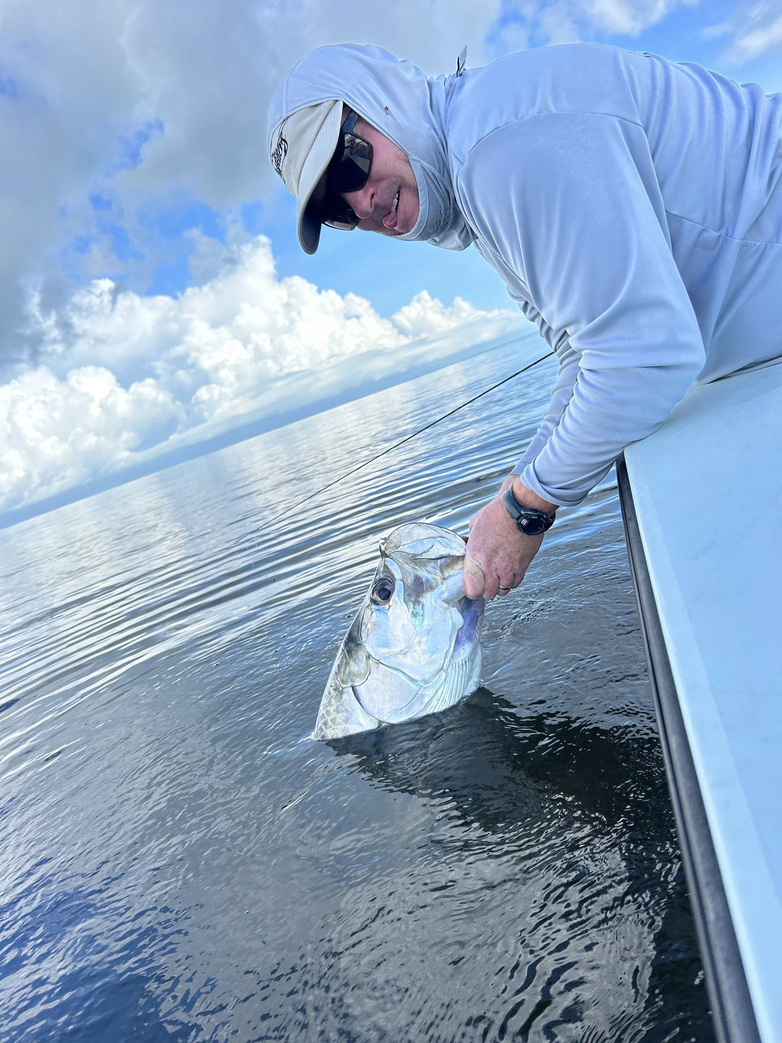 Saltwater flyfishing adventure in the Florida Keys, featuring a guided angler landing a tarpon on the flats near Islamorada.