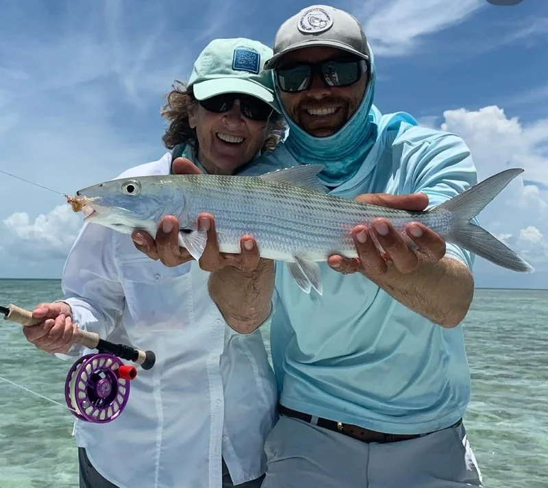 Smiling anglers holding a bonefish caught on fly rod in the shallow flats of the Florida Keys. Bonefishing in Islamorada and Biscayne Bay offers exciting fly fishing opportunities, with this prized inshore species..