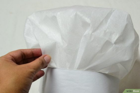Hand holding a white tissue or napkin against a plain light background.