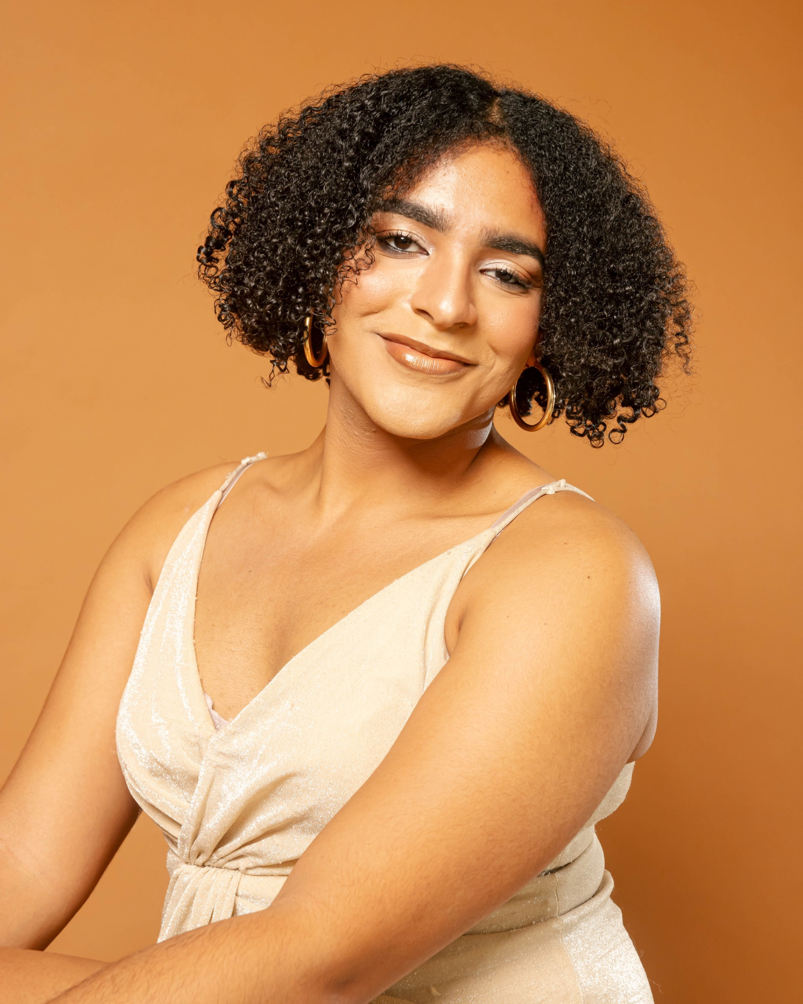 Saphire Headshot, Woman in Cream Colored Dress Smiling