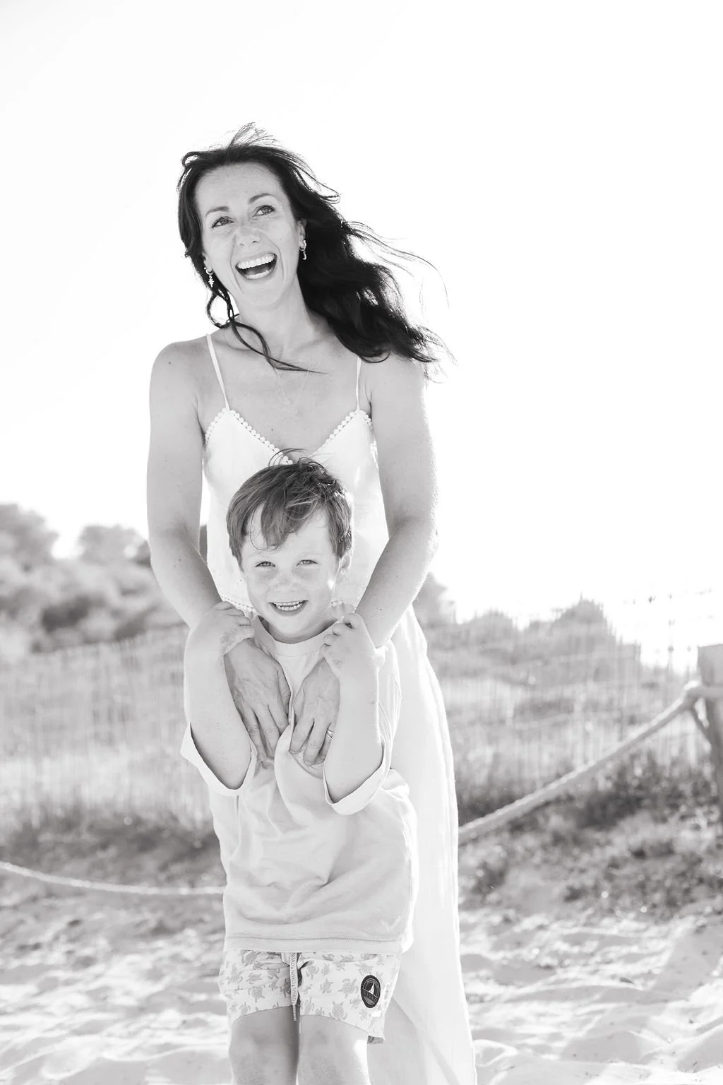 A happy woman with her happy son laughing on the beach