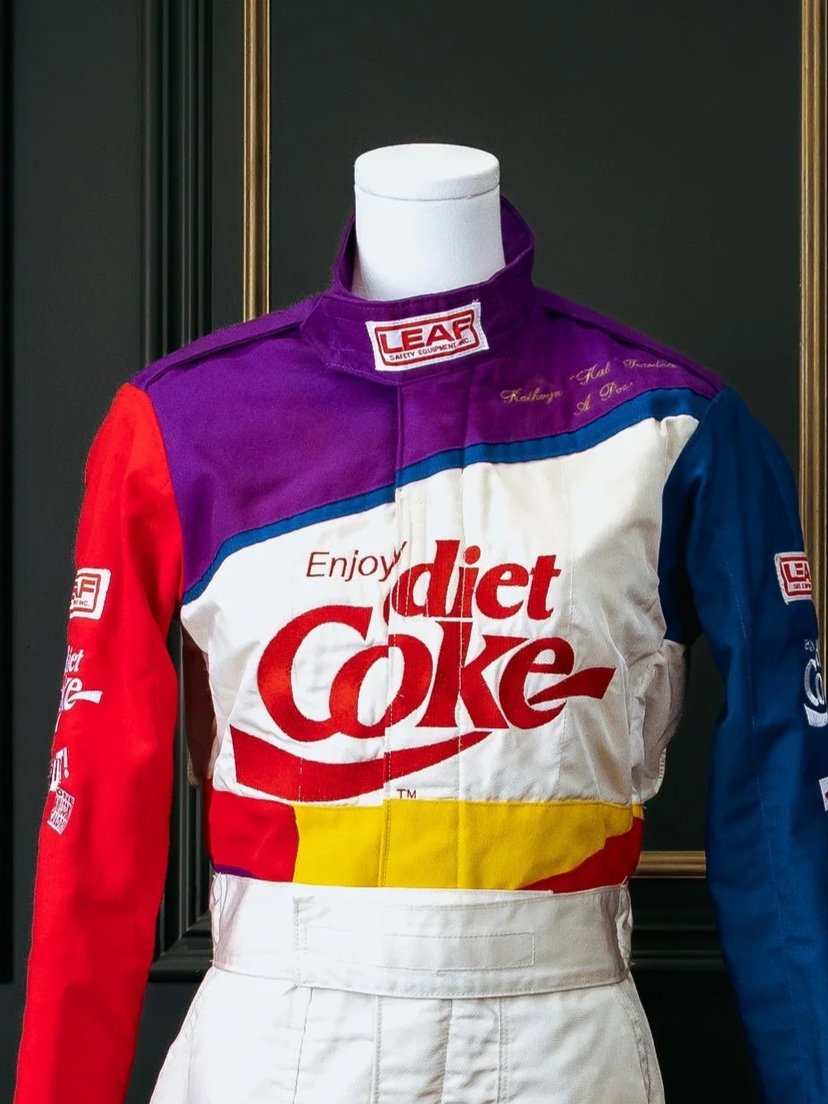 A racing suit with bold colors and advertising logos, including Diet Coke and Leaf Safety Equipment.