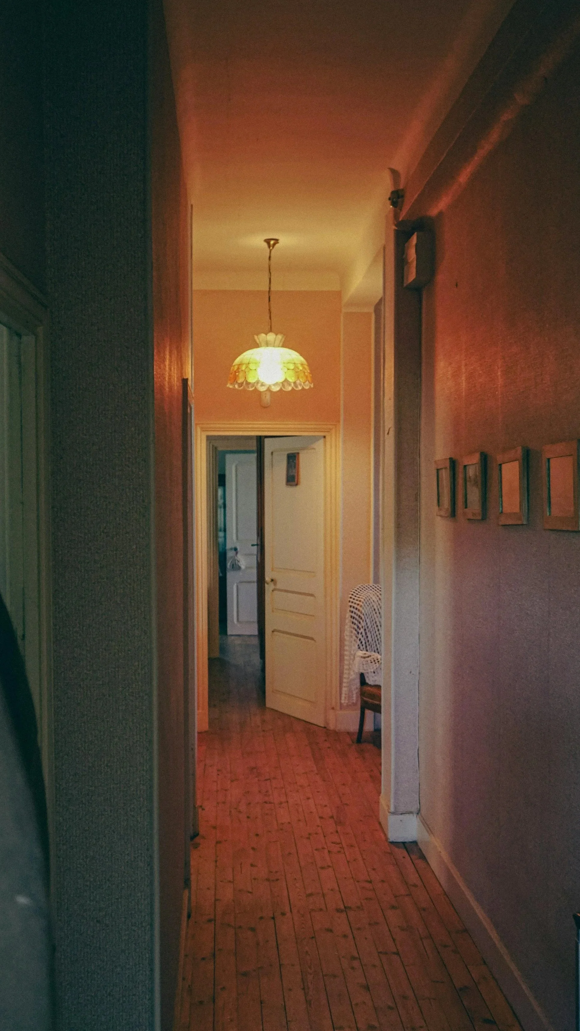 A warm, dim hallway with open doors, reflecting emotional distance and the vulnerability beneath relationship conflict.