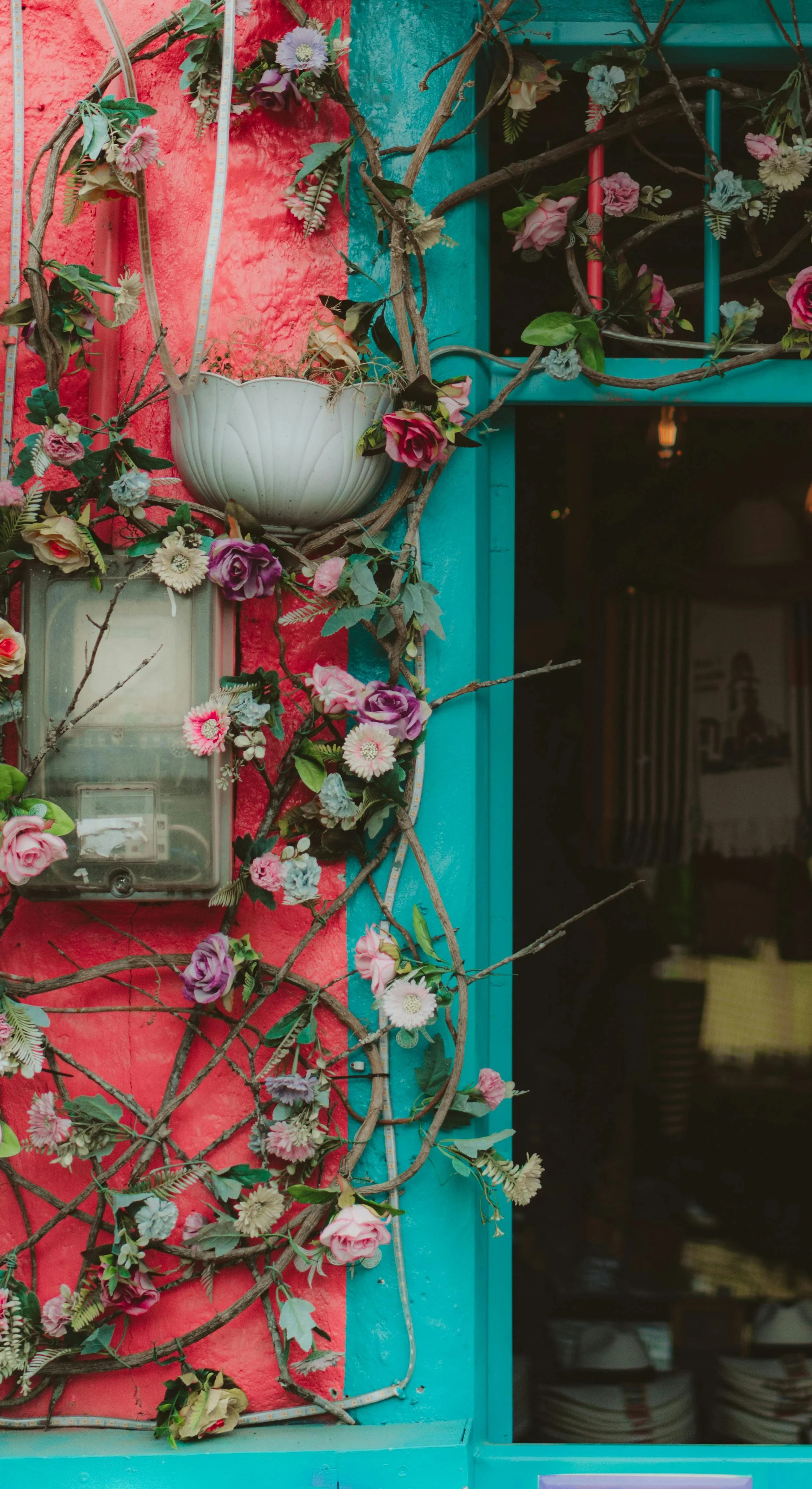 Colorful flowers arranged on a windowsill beside an open window, suggesting warmth, care, and everyday connection.