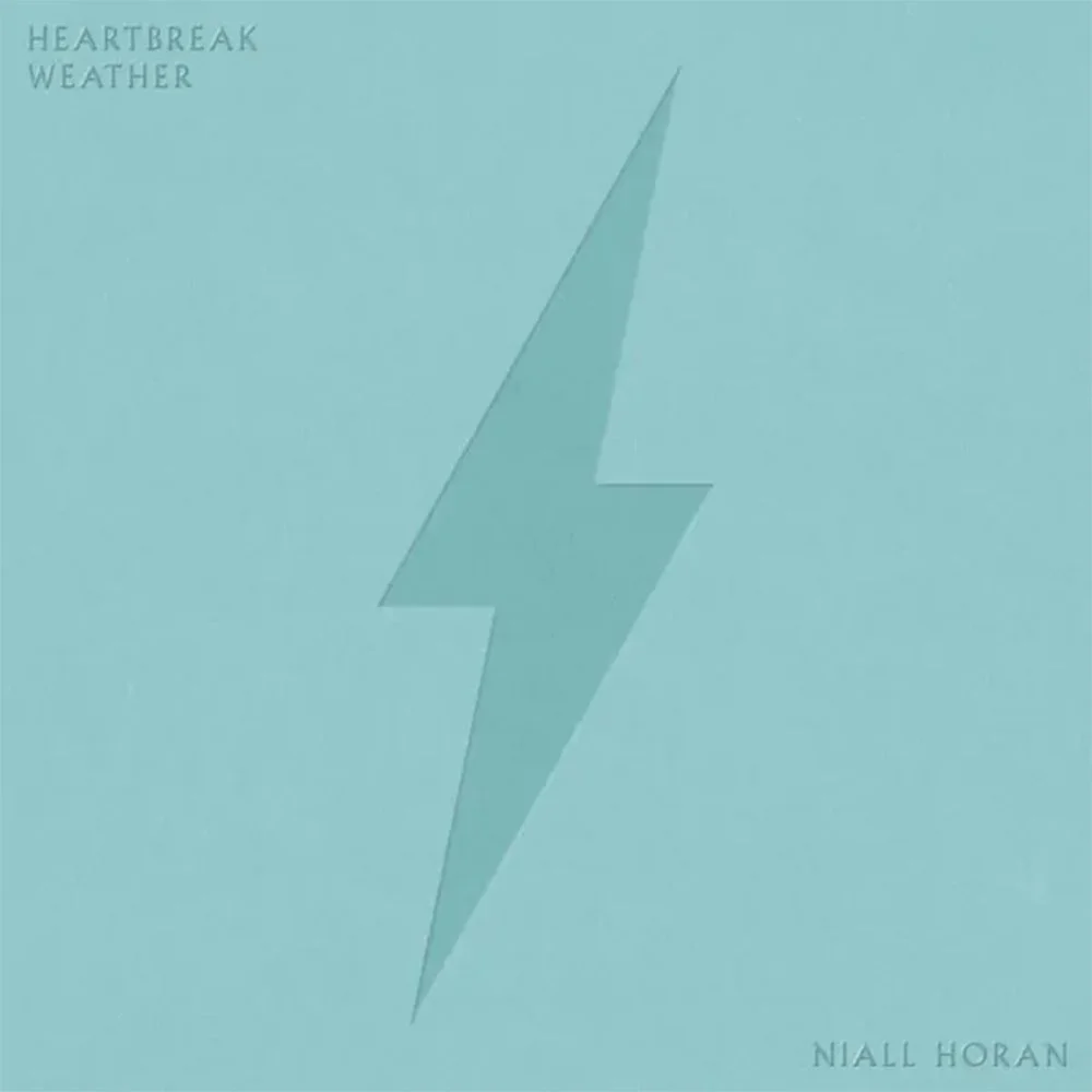 Cover of Niall Horan's song 'Heartbreak Weather' featuring a light blue background with a large, slightly darker blue lightning bolt in the center and the words 'HEARTBREAK WEATHER' in the top left corner.