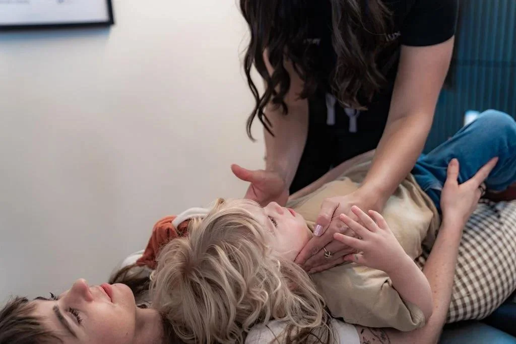 Pediatric chiropractic adjustment with a parent at InnerLux in Denver