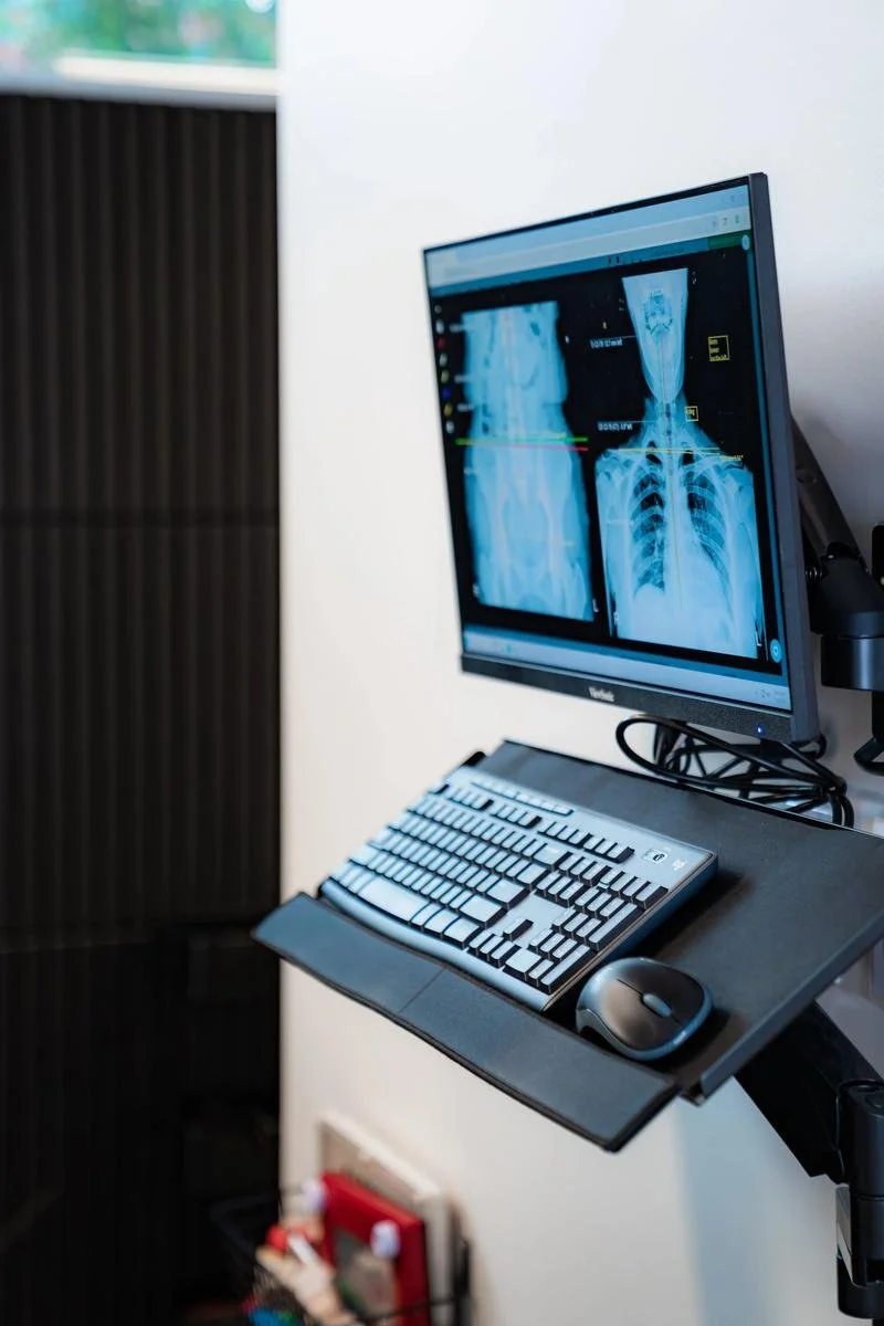 Cervical spine X-ray displayed on screen at InnerLux Healing Collective in Denver, CO.