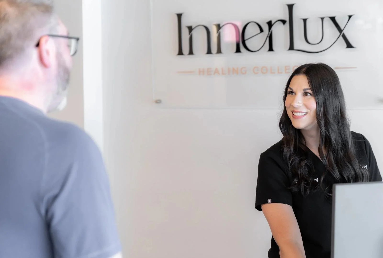 Patient checking in with a doctor at the front desk of InnerLux Healing Collective in Denver, CO.
