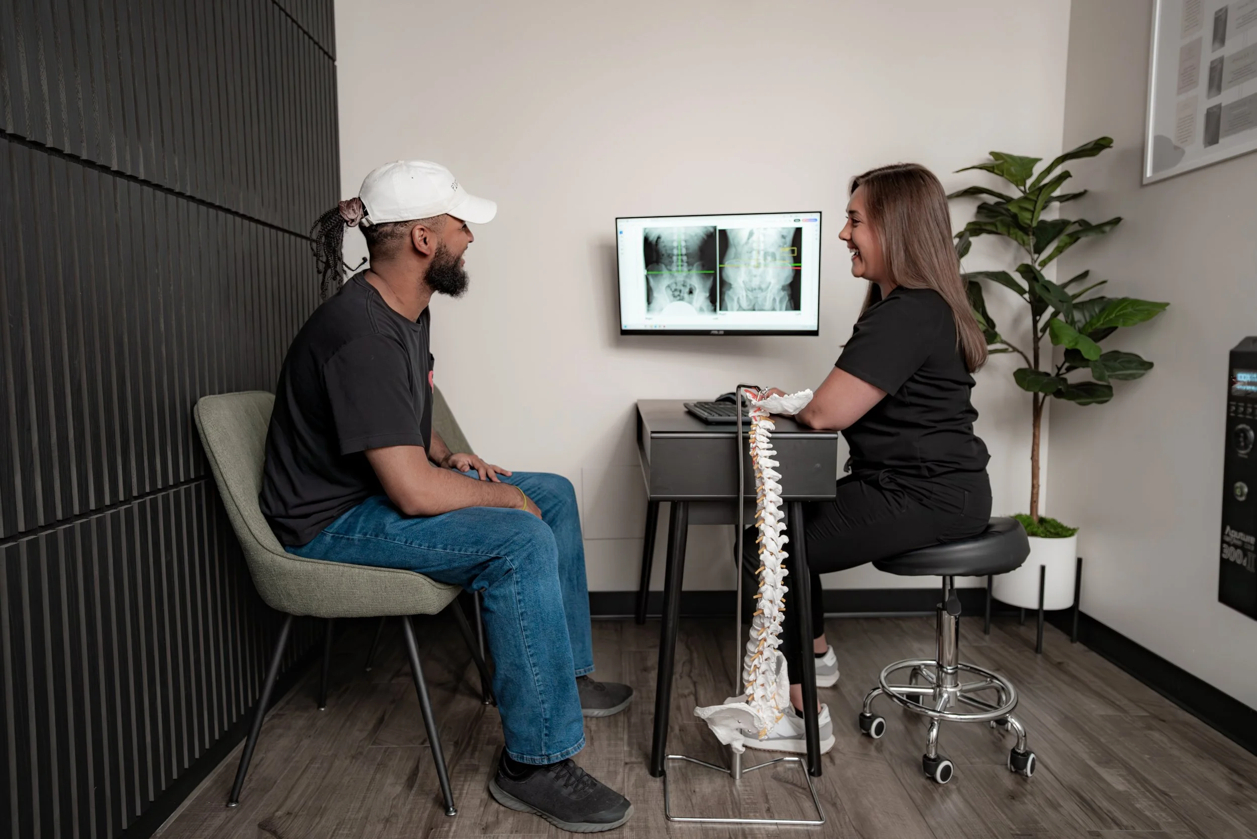 Chiropractor reviewing spinal X-rays with a patient during a report of findings in Denver
