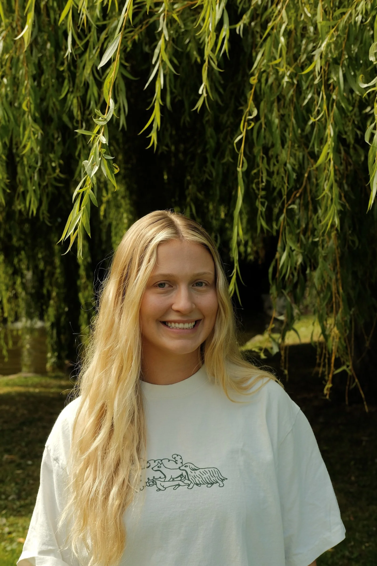 Aubrey, smiling in front of a forested background