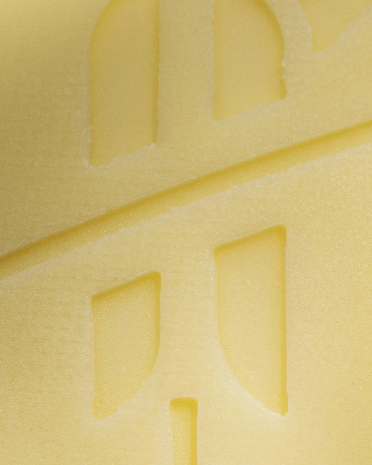 Close-up of a yellow foam or sponge with geometric cutouts.
