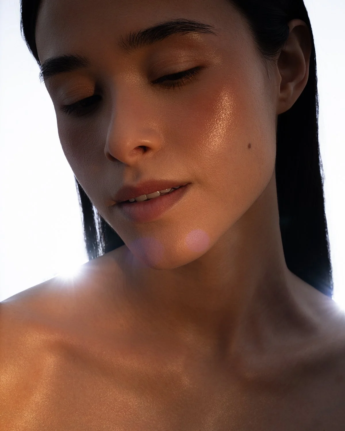A close-up of a woman with smooth, glowing skin and closed eyes, with a bright light behind her creating a backlighting effect.