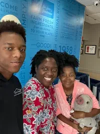 Wendy Zanders smiling with her two children, sharing a personal moment that reflects her family-centered approach as a professional organizer and declutter coach.