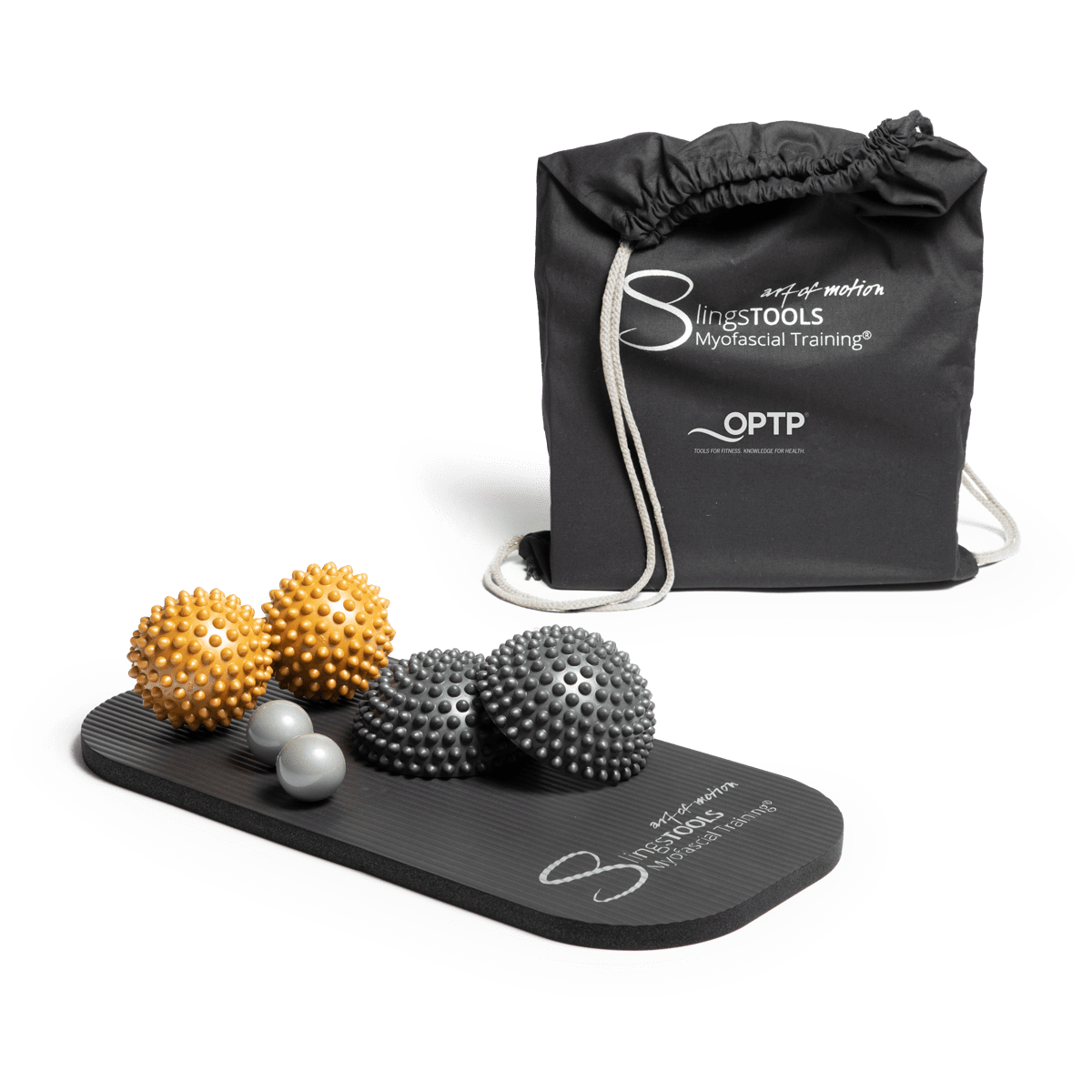 Set of massage therapy tools including spiky massage balls in gold and gray, two smooth white massage balls, and a black textured massage mat, next to a black drawstring bag.
