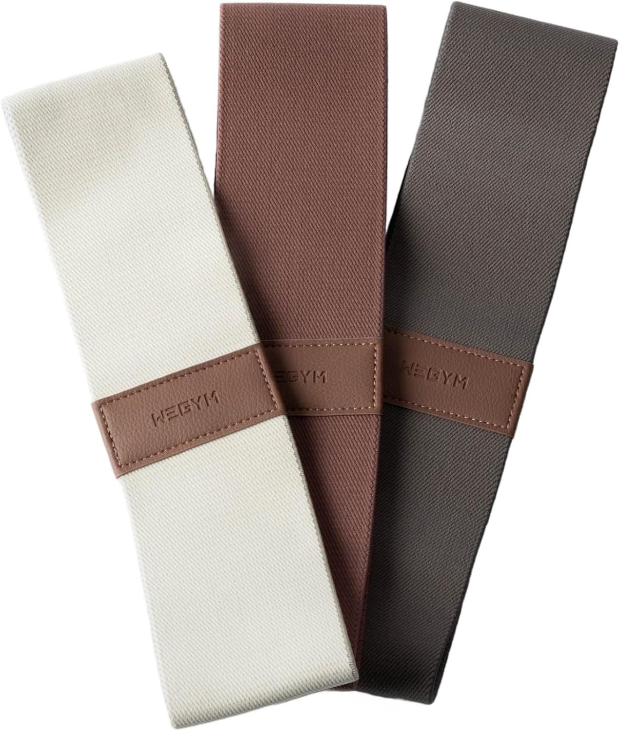 Three resistance bands in white, brown, and dark gray with brown leather labels embossed with 'NEBGYM'