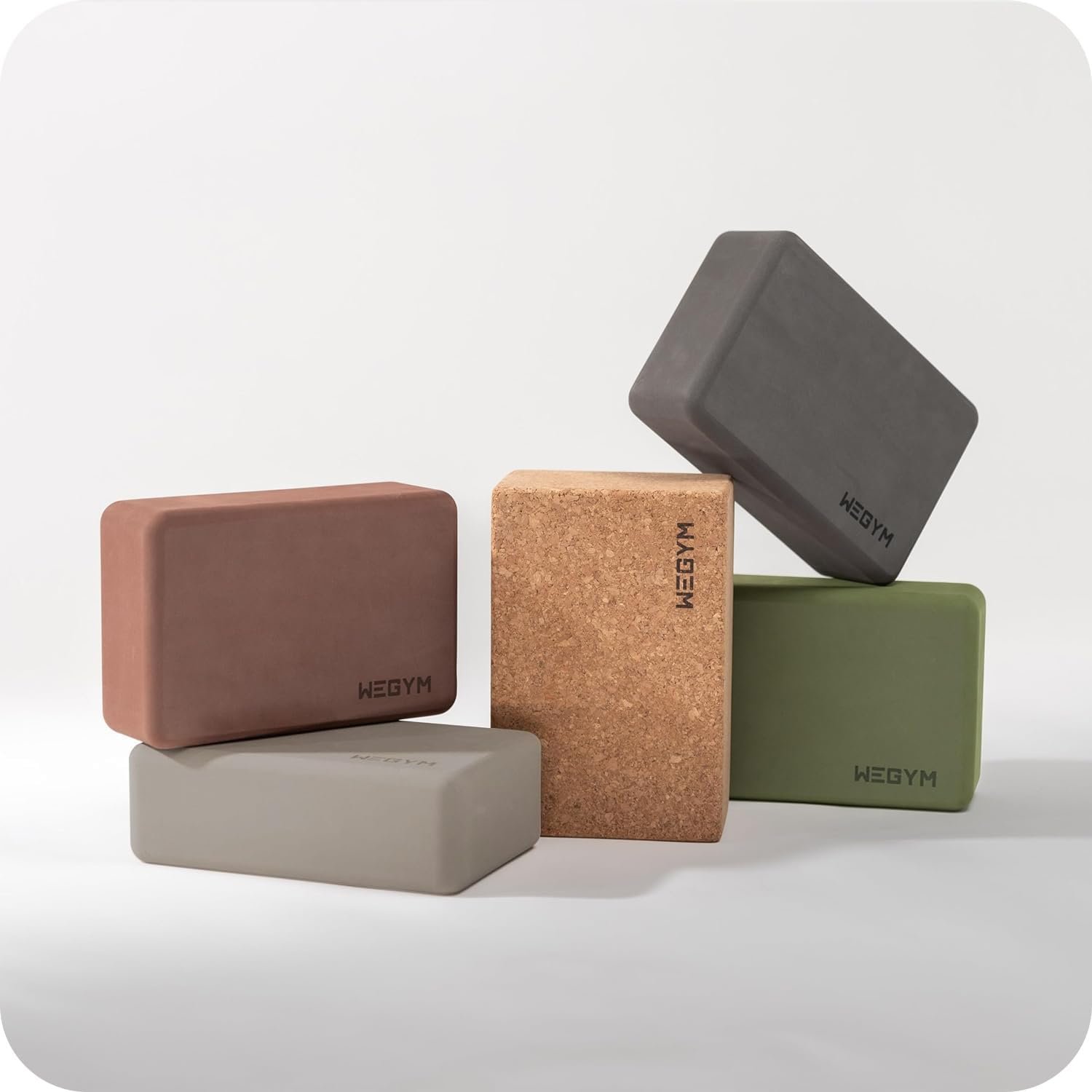 Colorful yoga blocks stacked on a white surface with a plain white background.