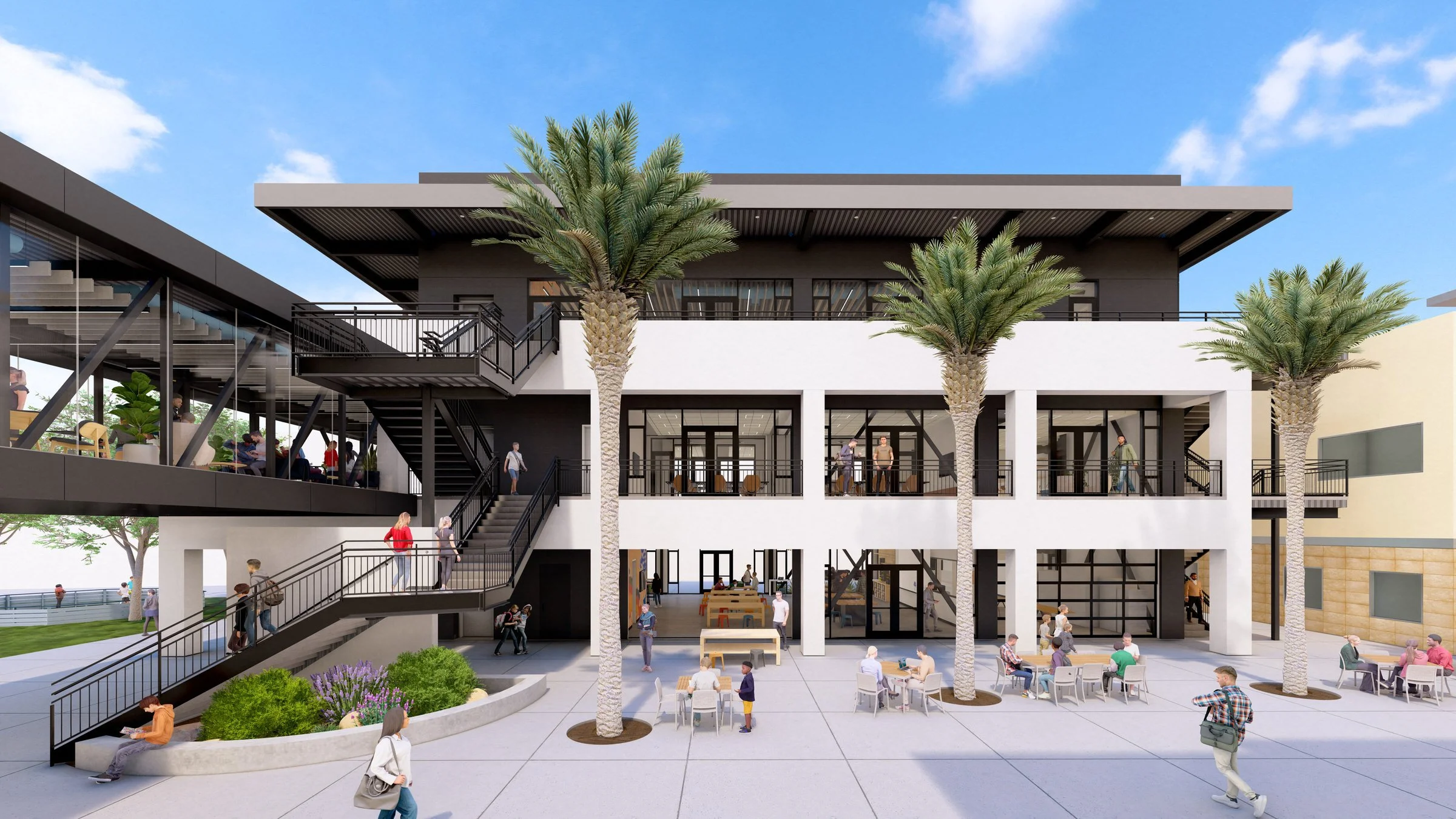 Modern two-story building with large windows, outdoor seating area, and palm trees. People walking and sitting around tables on ground level. Exterior staircases leading to the second floor.