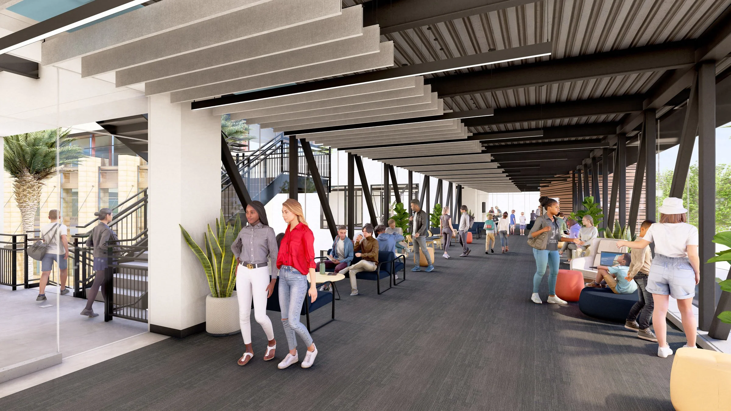 Indoor corridor with people socializing, sitting on modern furniture, staircase in the background, plants along the pathway, and a glass wall. The corridor is a bridge spanning The Hub for Human Impact.