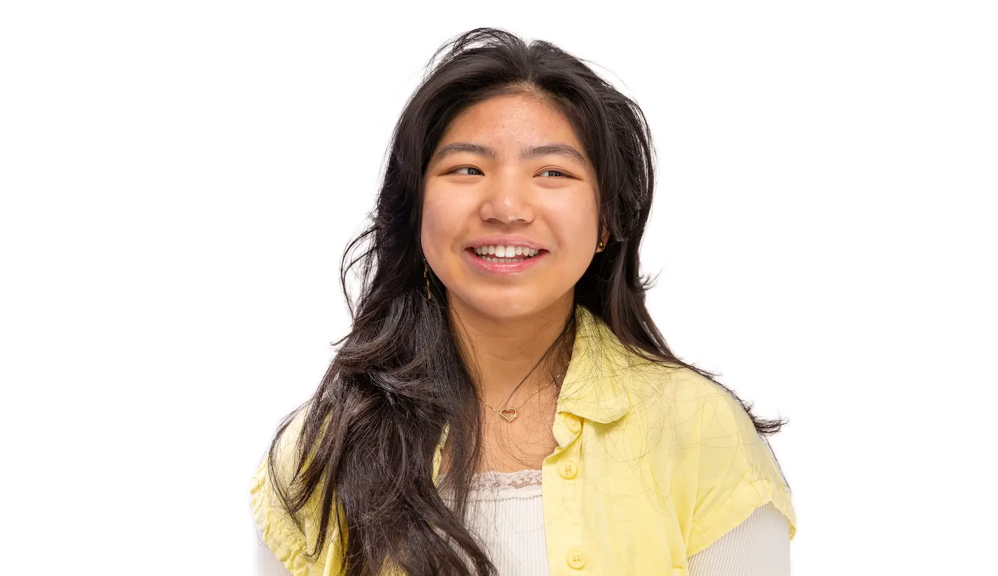 A young woman with long dark hair, smiling, wearing a yellow cardigan over a white top, with earrings and a necklace, against a white background.