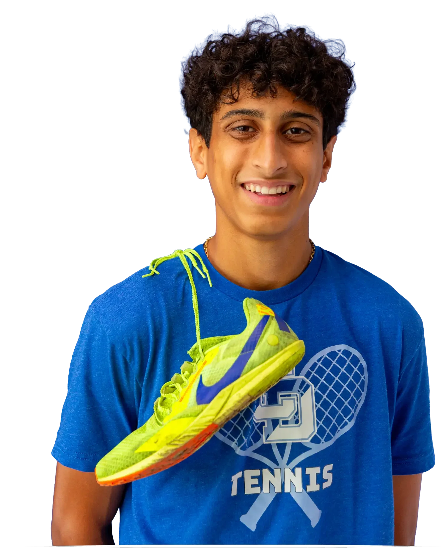 A young person with curly hair wearing a blue tennis shirt holding a bright yellow tennis shoe.