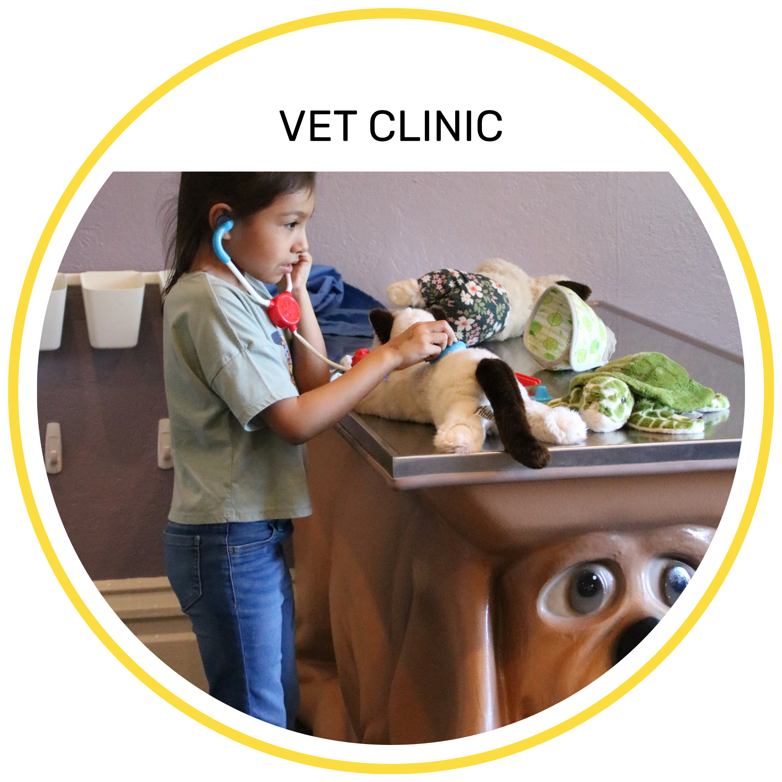Child wearing a scrub shirt leaning over a life-sized pretend animal to examine it in the Vet Clinic exhibit.