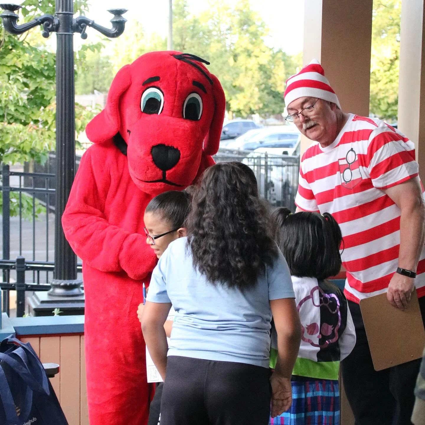 Clifford the Big Red Dog and Waldo greet families at the museum entrance during a Storybook Adventure rental.