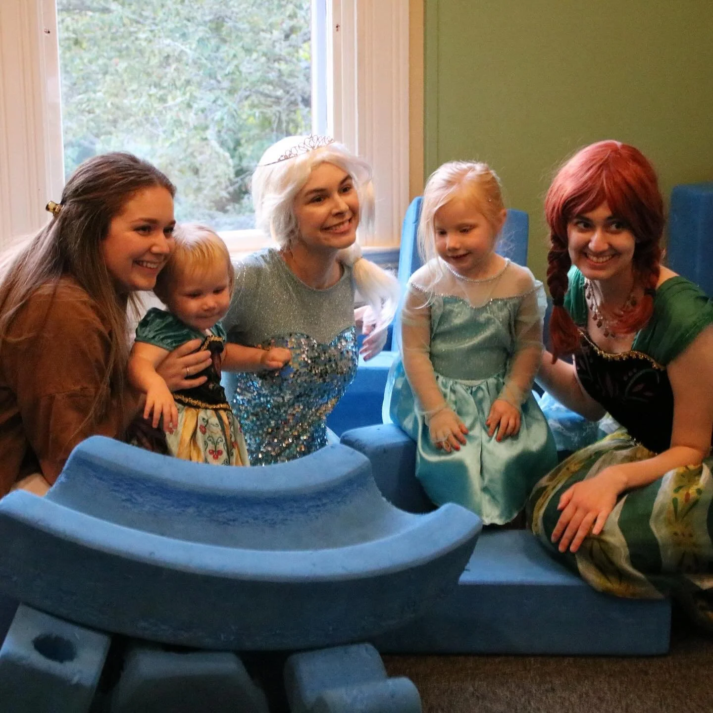 Elsa and Anna characters interact with toddlers in a blue foam block play area during a private museum rental.