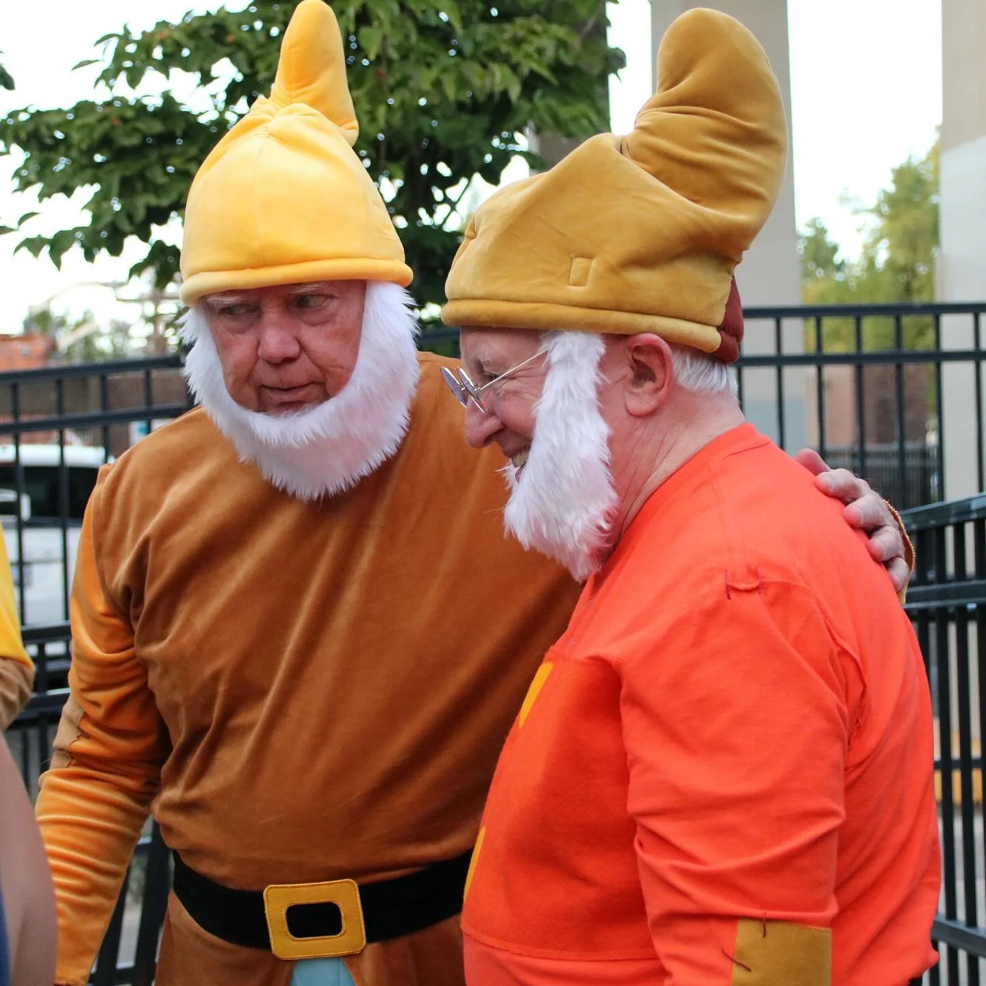 Two men dressed as dwarf characters from Snow White pose at a themed Storybook Adventure family event.