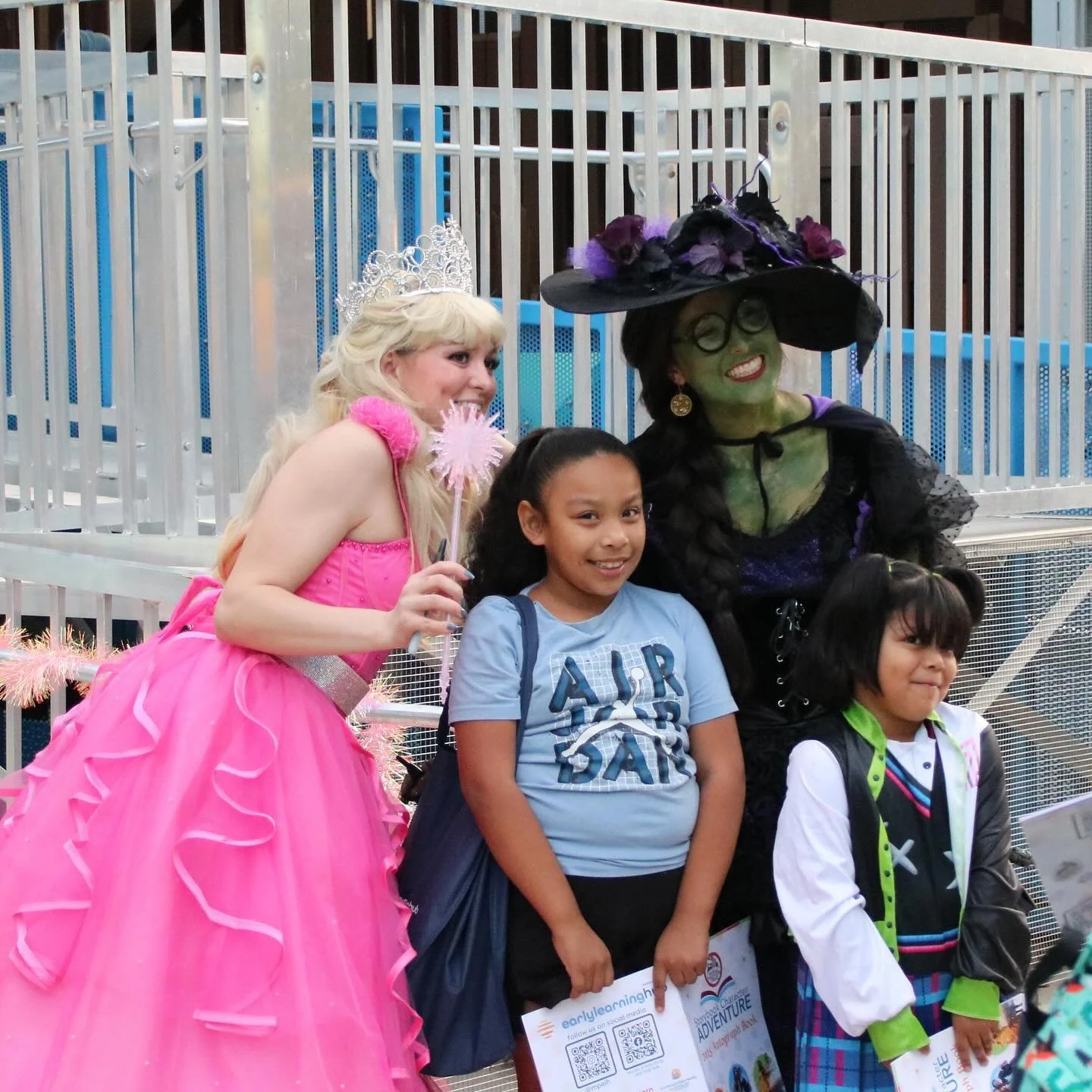 A Princess and Wicked Witch character pose with a young guest at a themed Storybook Adventure evening event.