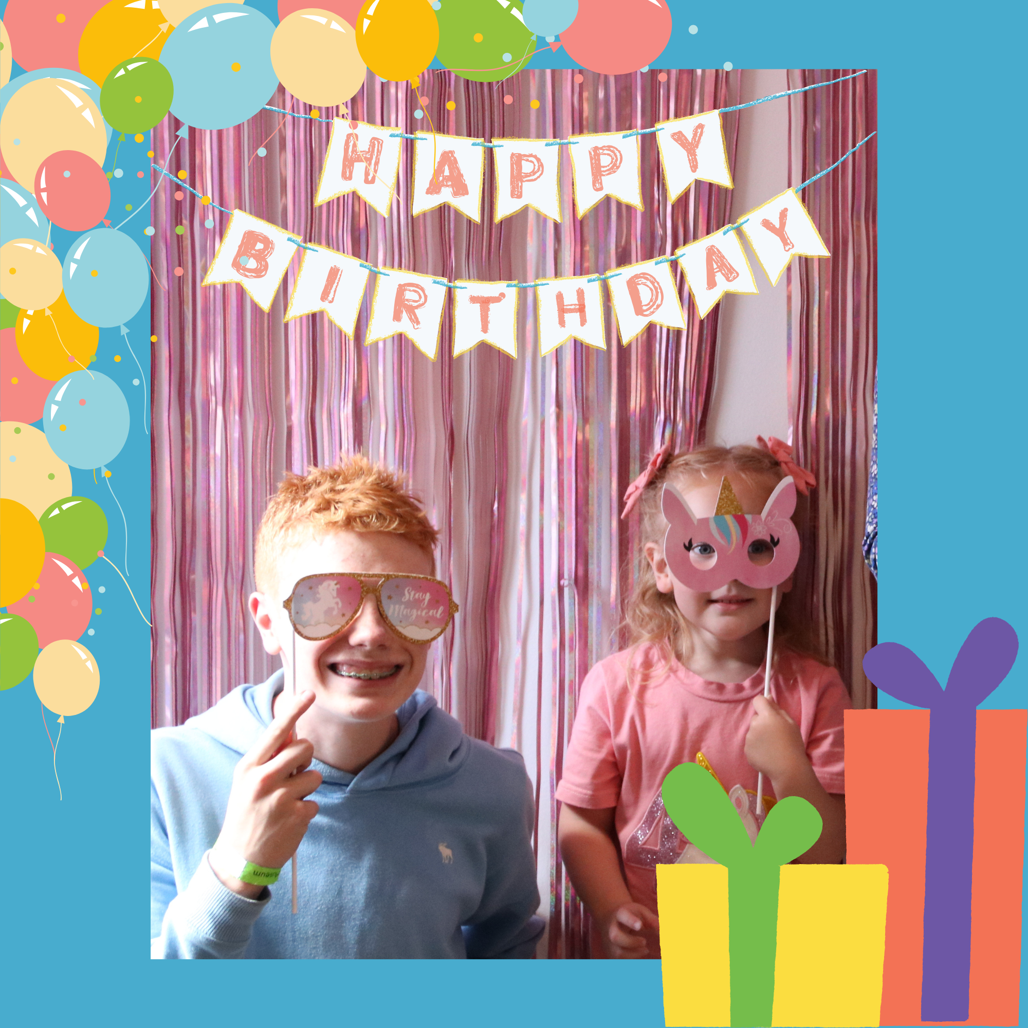 Two smiling children wear silly party glasses in front of a pink birthday banner and large gift boxes.