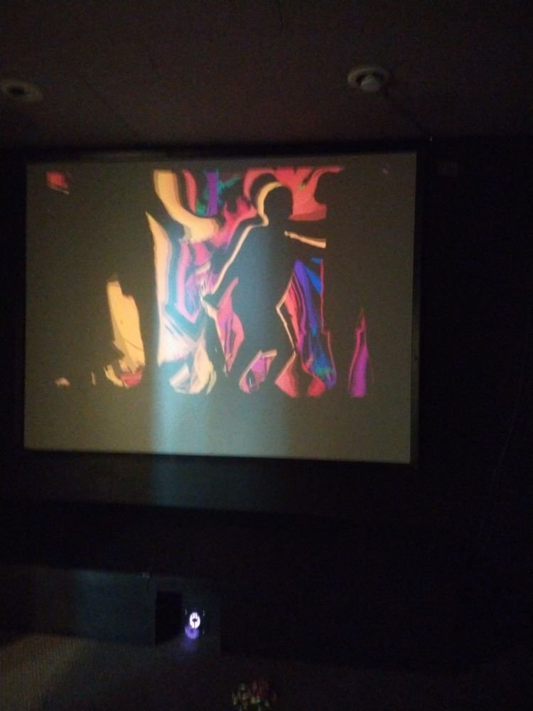 Silhouette of a person walking, surrounded by abstract colorful shapes.