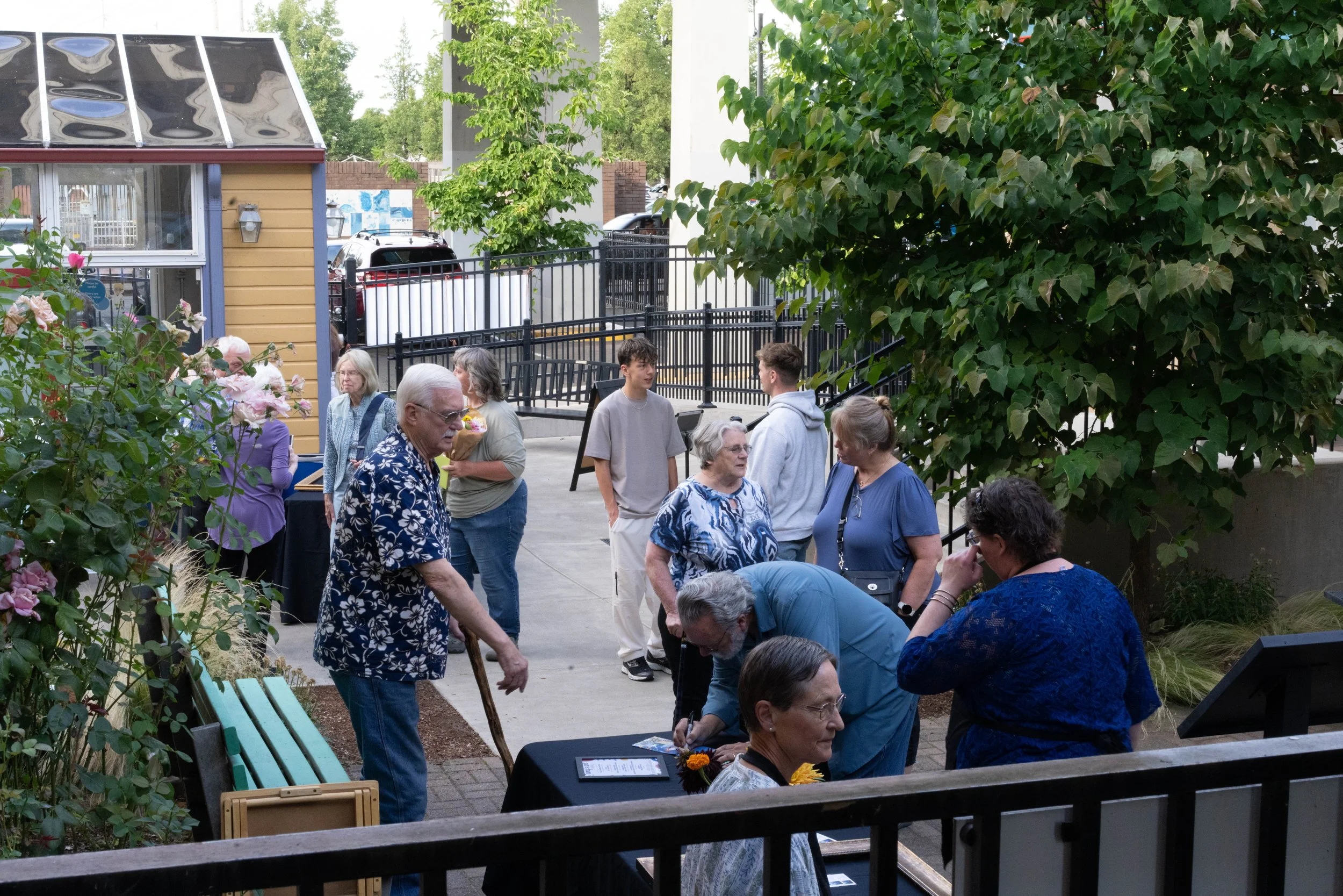 Evening rental guests mingling on the outdoor patio near the historic Victorian houses and gardens.