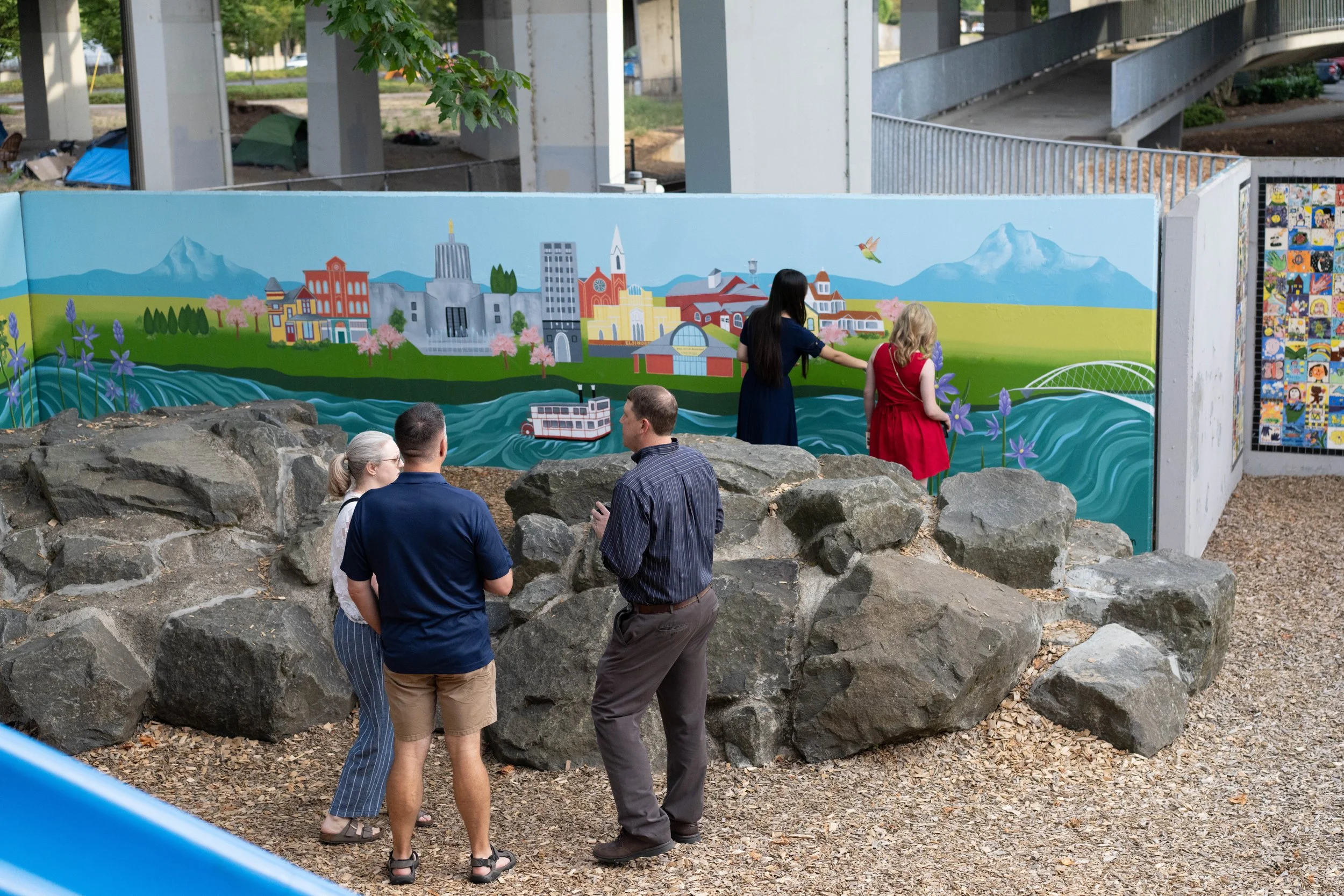 Guests at the evening internship reception admiring a vibrant nature mural in the Outdoor Discovery Area.