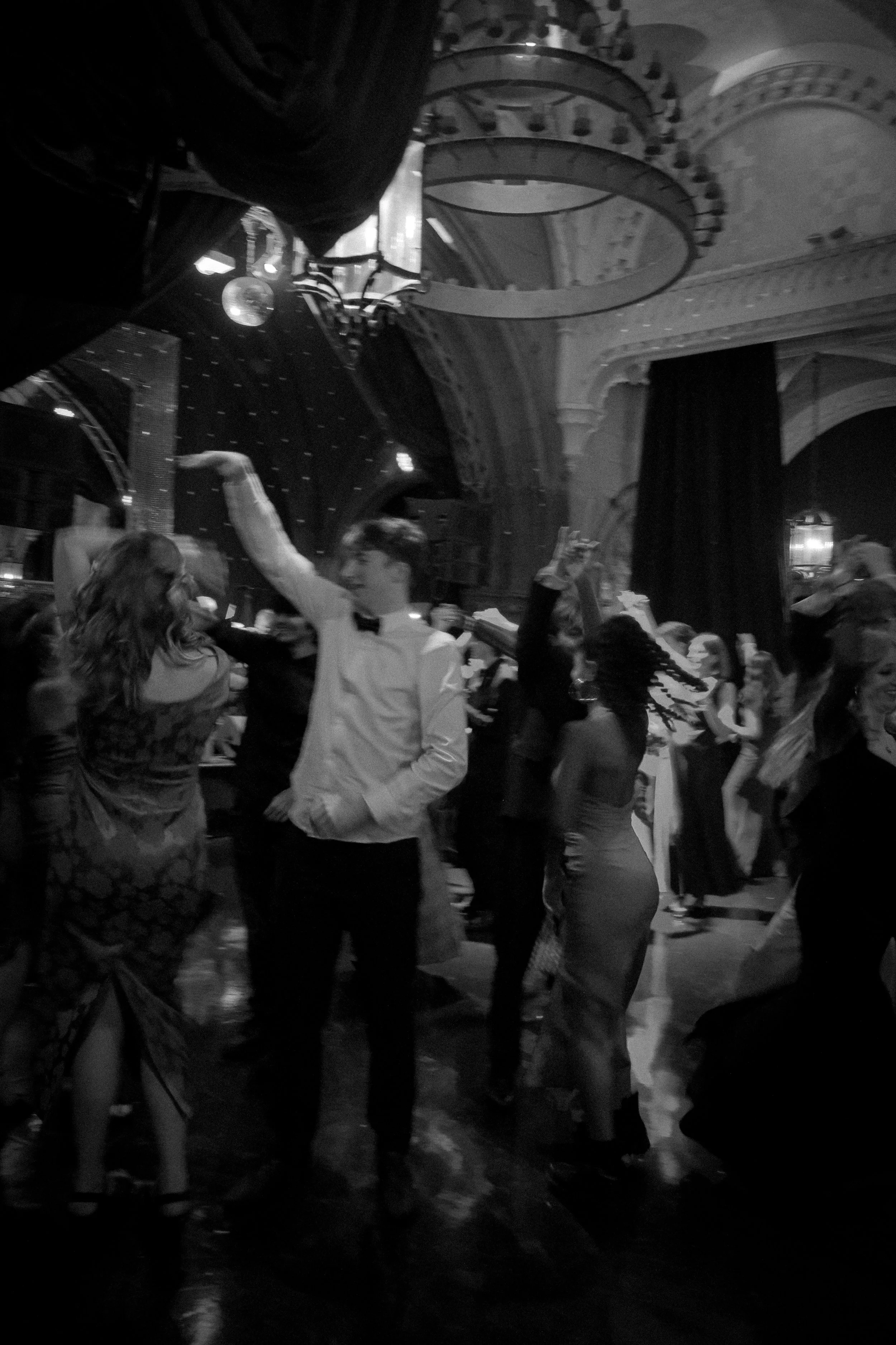 People dancing at a formal event or dance party in a decorated venue.