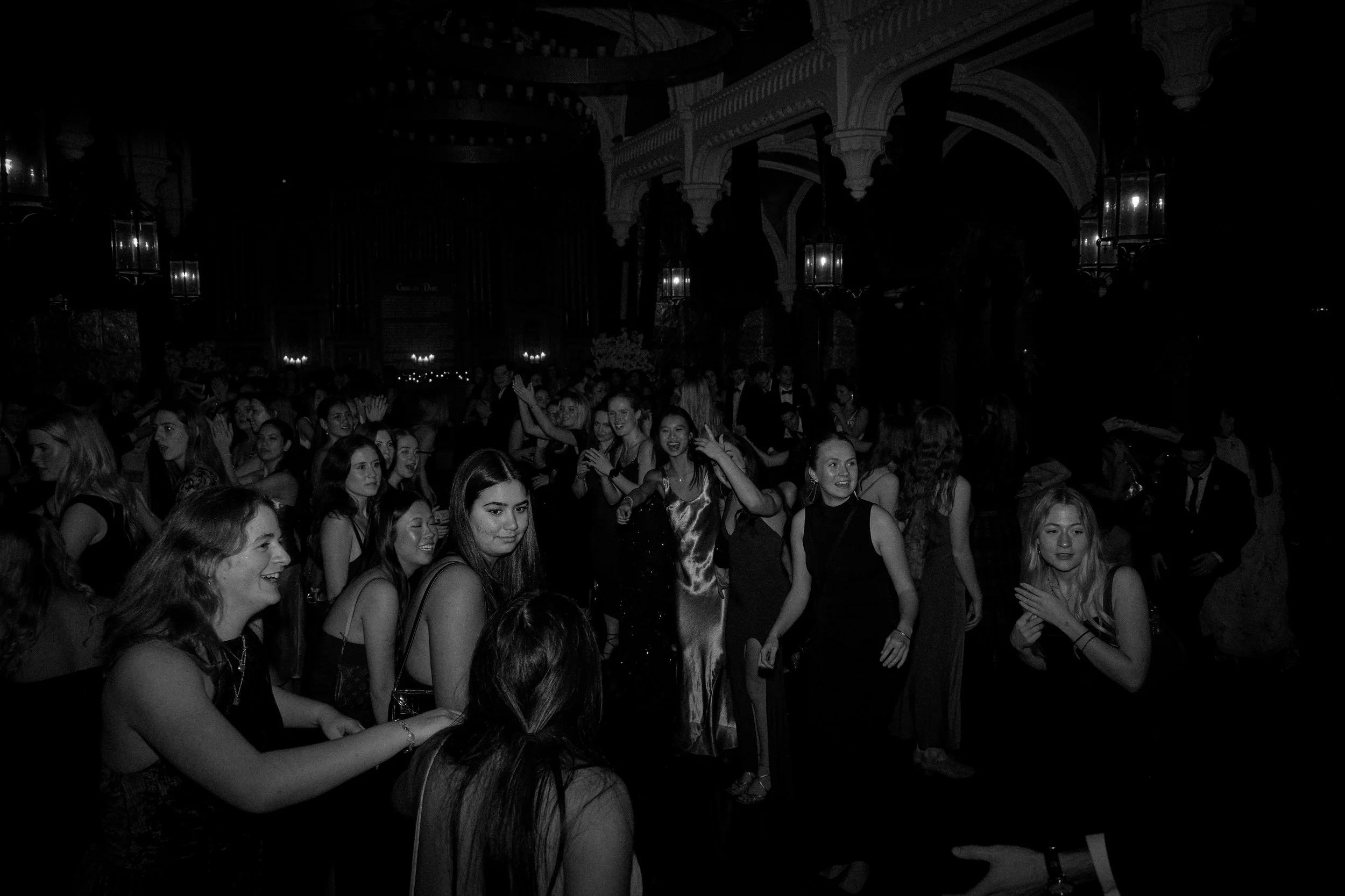 People dancing and socializing at an indoor event or party in a dimly lit venue.