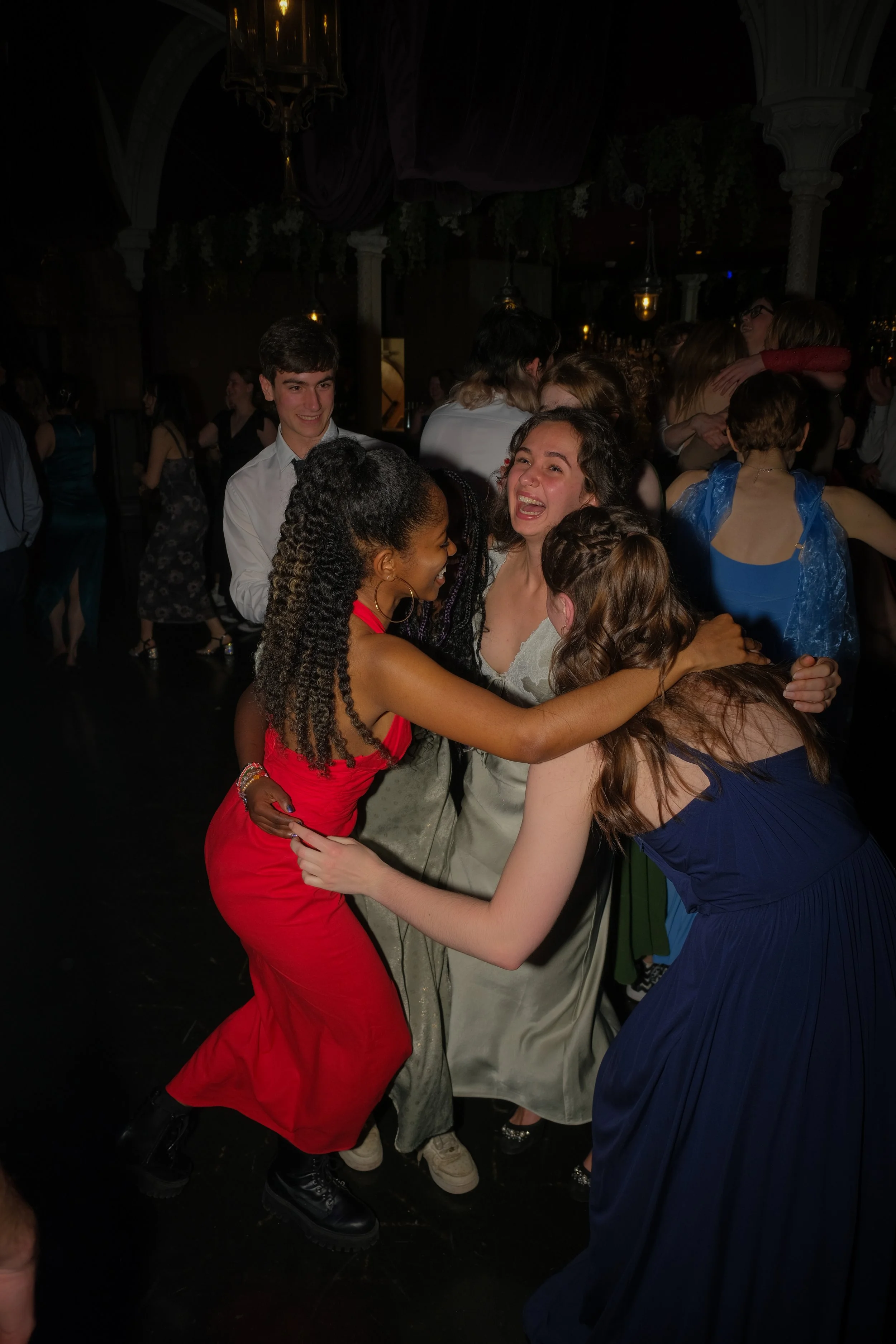 Group of young people dancing and celebrating at a party or dance event, with smiling faces and lively interactions.