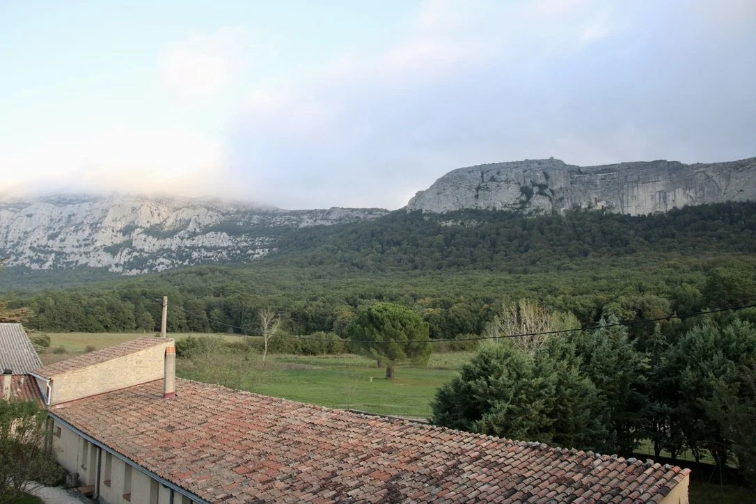 In the right side of this photo, where the green of the forest meets the grey of the cliff, you can see the church built around the cave where Mary Magdalene is said to have lived